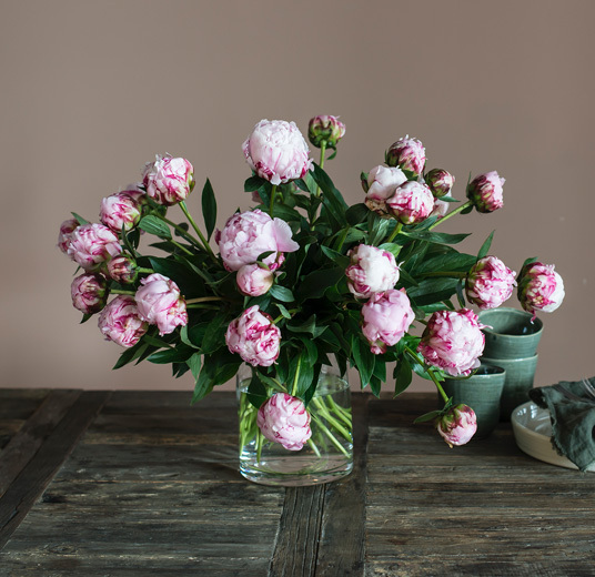 peoner-paa-bord-i-glassvase.jpg